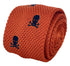 orange knitted tie with embroidered navy skull and crossbone design