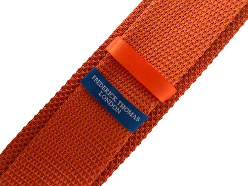 orange knitted tie with embroidered navy skull and crossbone design
