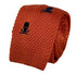 orange knitted tie with embroidered navy skull and crossbone design