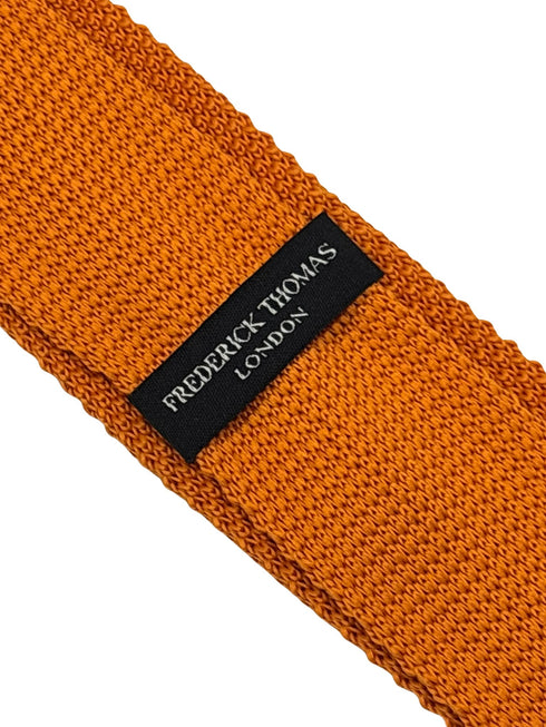 knitted tie in bright orange with emerald green polka dots