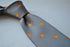 grey tie with orange polka dots