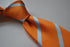 orange tie with light blue club stripes