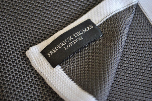 grey knitted pocket square with white edging