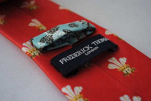red tie with prince of wales feathers badge