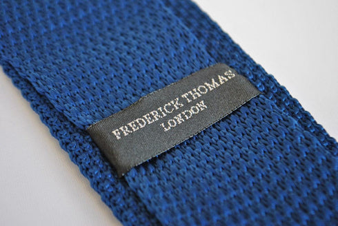 navy blue skinny knitted tie with white polka dots and pointed end